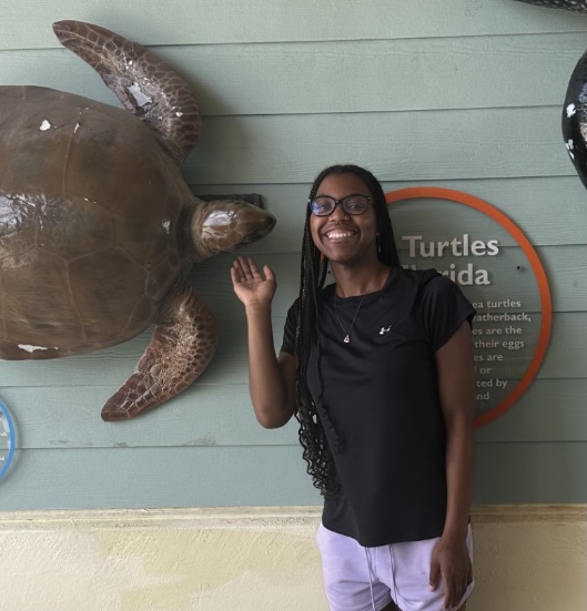 Kamill Thompson standing next to an educational display about turtles.